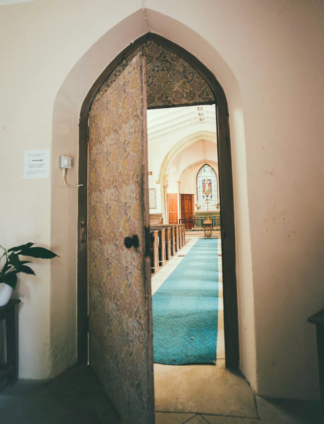 Church interior viewed through an open arched doorway.